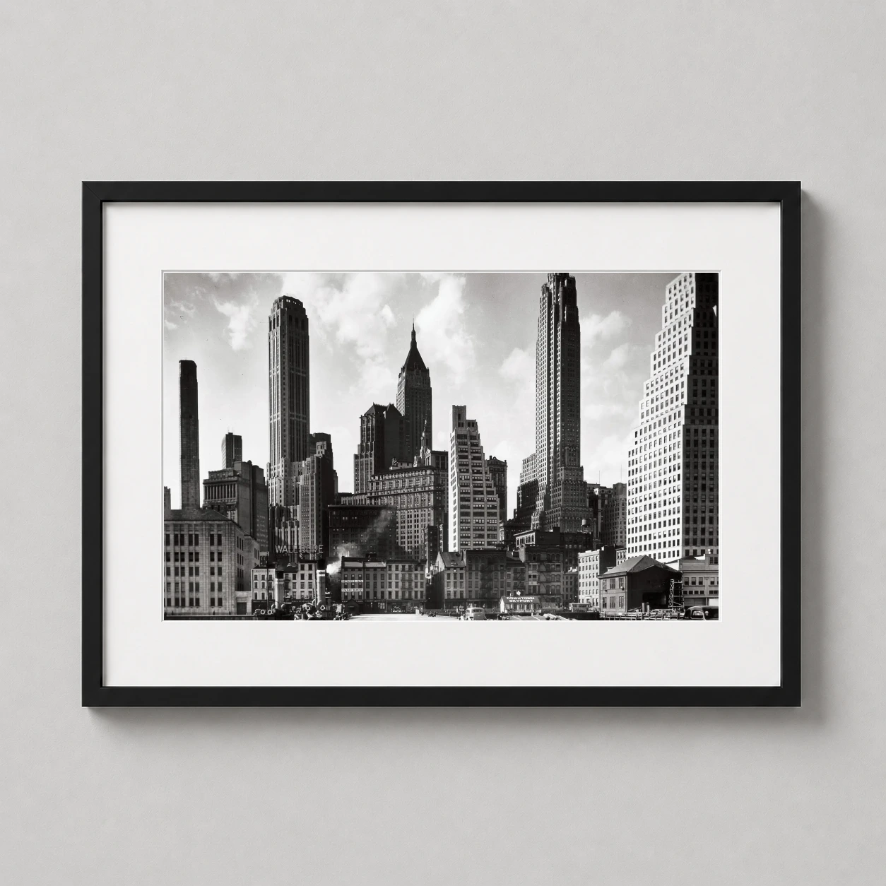 Room mockup of Berenice Abbott, Downtown Manhattan c.1935 NYC Photography Print, displayed as framed wall art in a office setting as a landscape print with black and white tones.