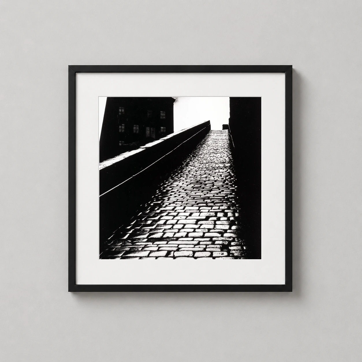Room mockup of Bill Brandt A Snicket in Halifax 1937 Photography Print, displayed as framed wall art in a office setting as a square print with black and white tones.