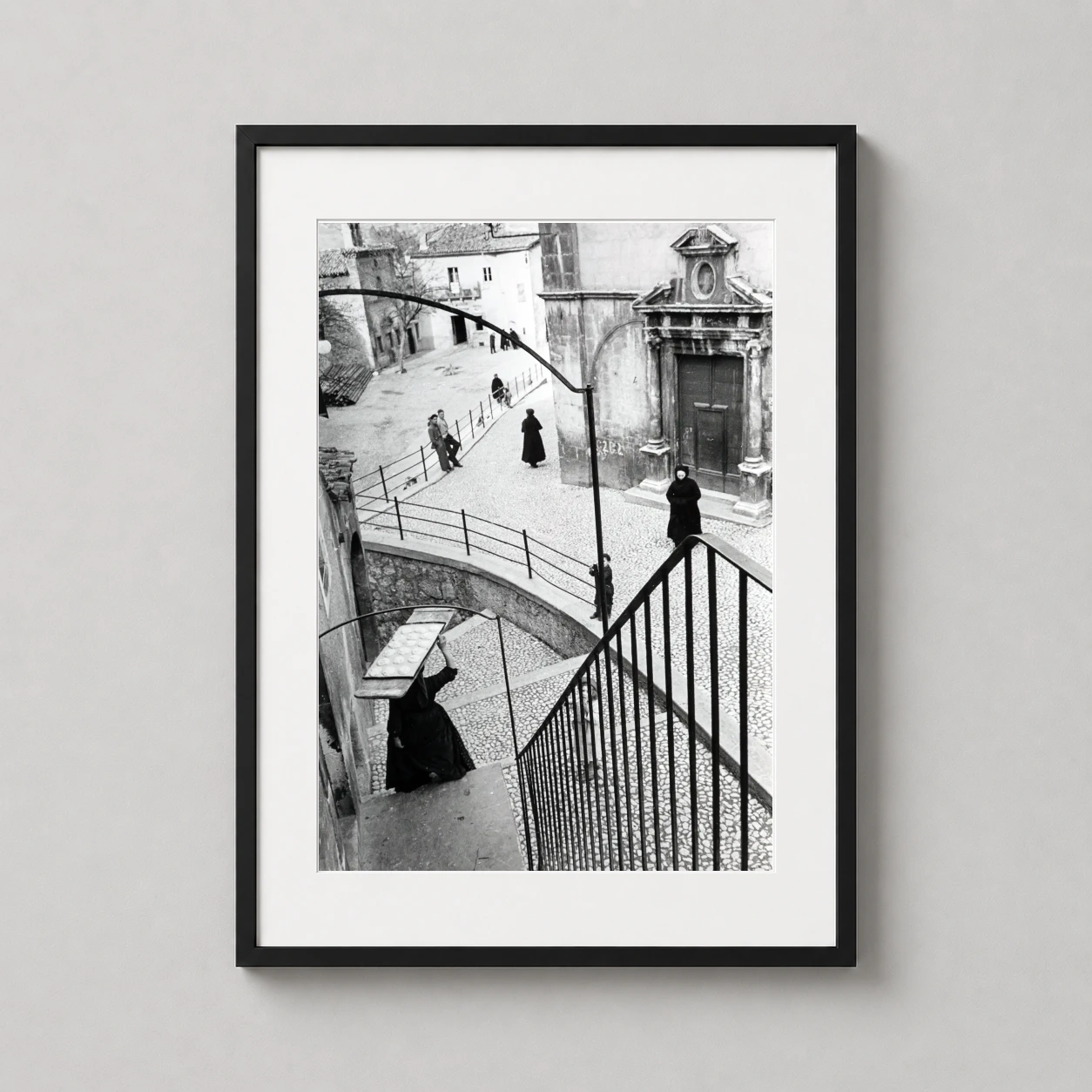 Henri Cartier-bresson Scanno Italy — high-angle black and white photograph of a woman carrying a tray of