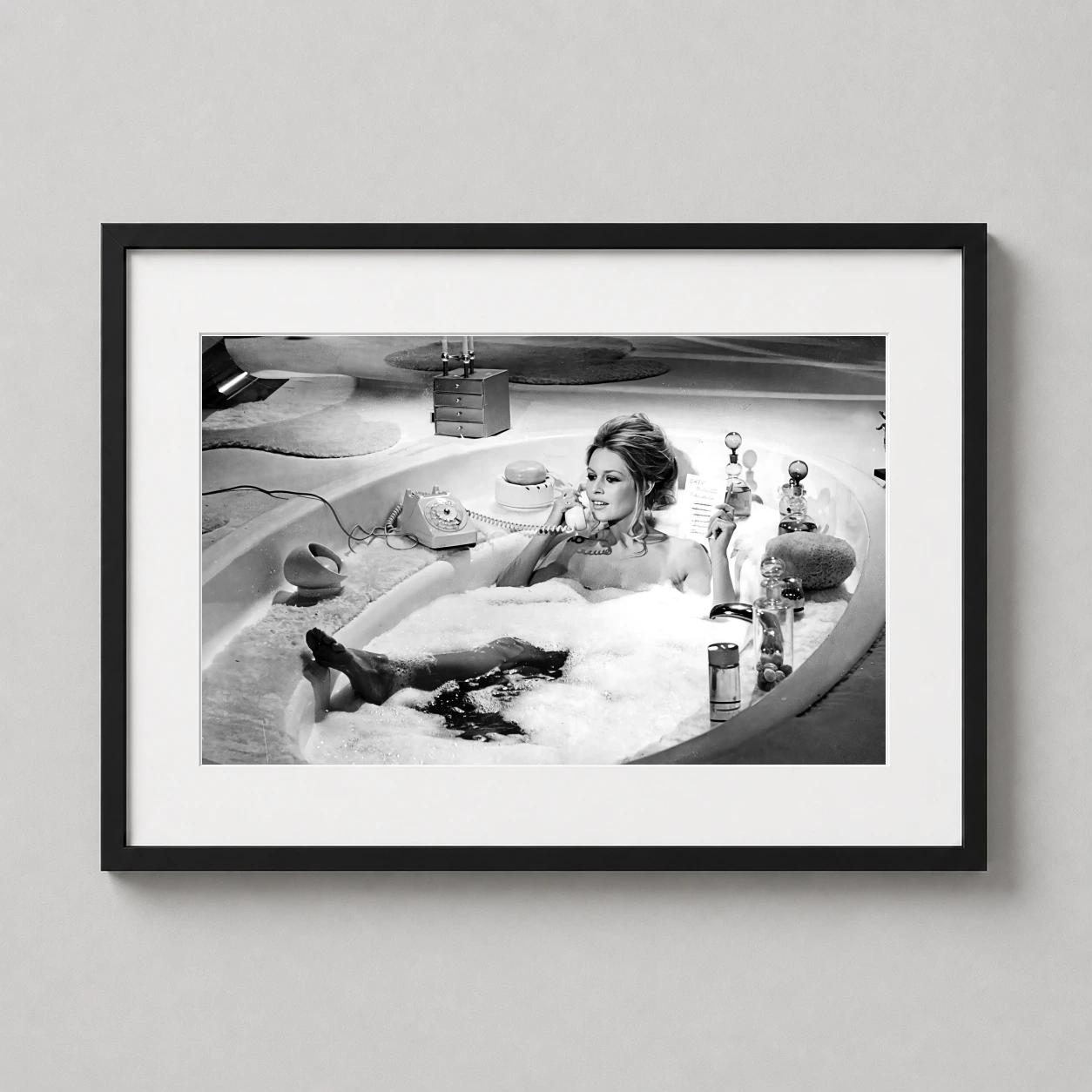 Room mockup of Brigitte Bardot Bathtub Black and White Photography Print, displayed as framed wall art in a office setting as a landscape print with black and white tones.