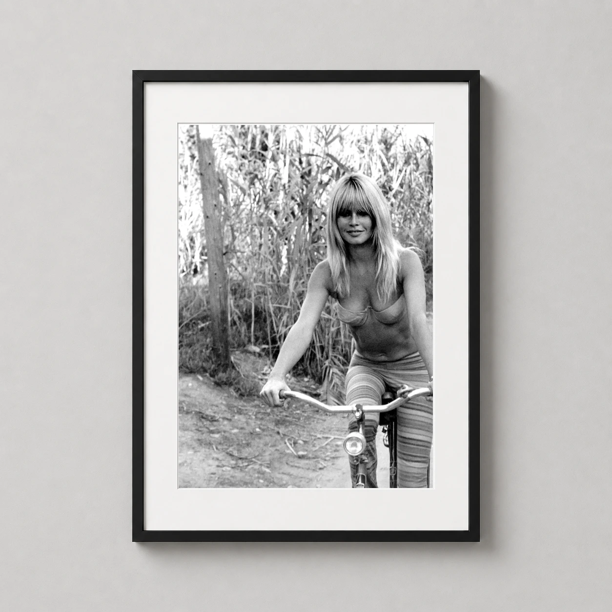 Brigitte Bardot Bicycle Black — brigitte Bardot rides a bicycle through a rustic outdoor setting in