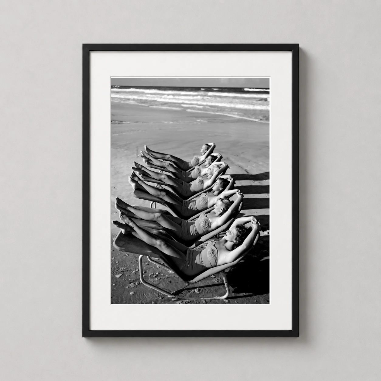 Women Sunbathing Beach — high-contrast black and white vintage photograph featuring six women in