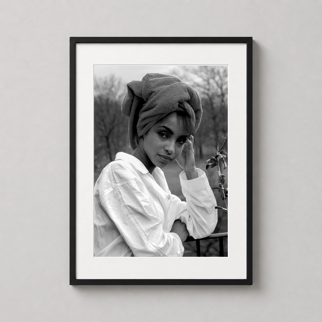 Room mockup of Sade Adu Black and White Portrait, Vintage Music Photography Print, displayed as framed wall art in a office setting as a portrait print with black and white tones.