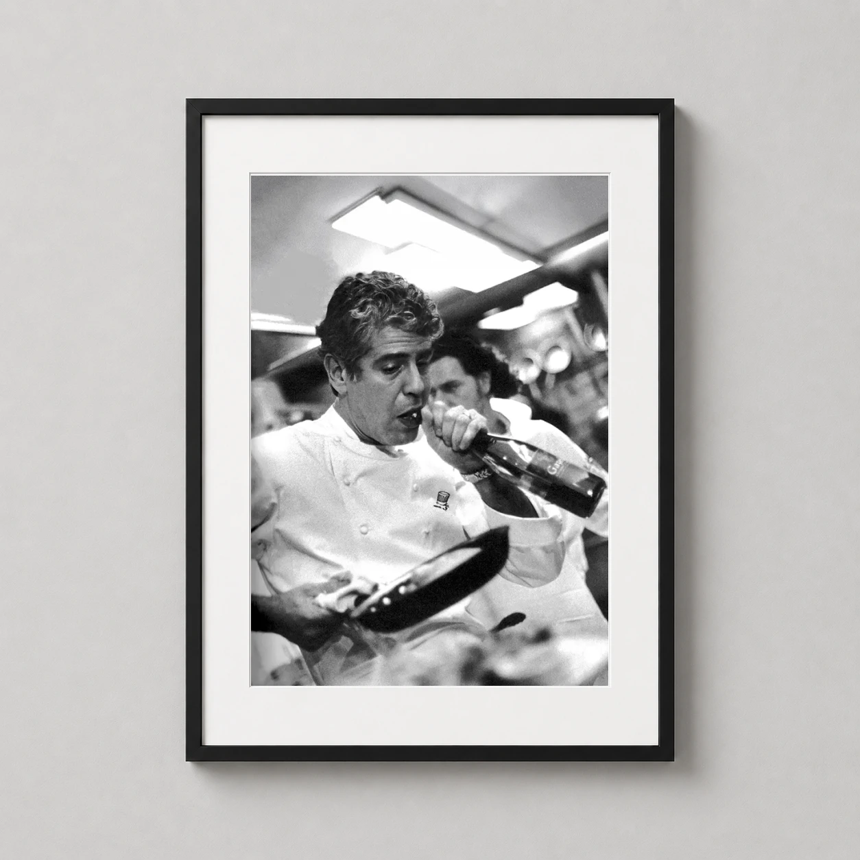 Room mockup of Anthony Bourdain Kitchen Photography Black and White Photography Print, displayed as framed wall art in a kitchen setting as a portrait print with black and white tones.
