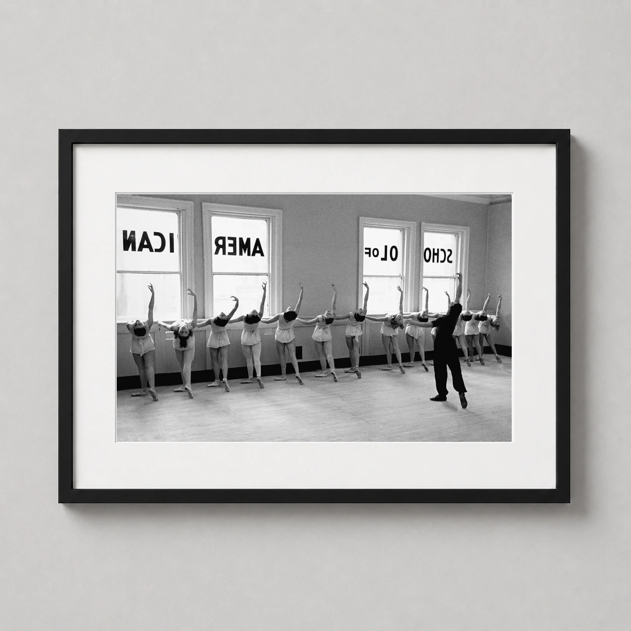 Room mockup of Ballerinas of the School of American Ballet Vintage Photography Print, displayed as framed wall art in a office setting as a landscape print with black and white tones.