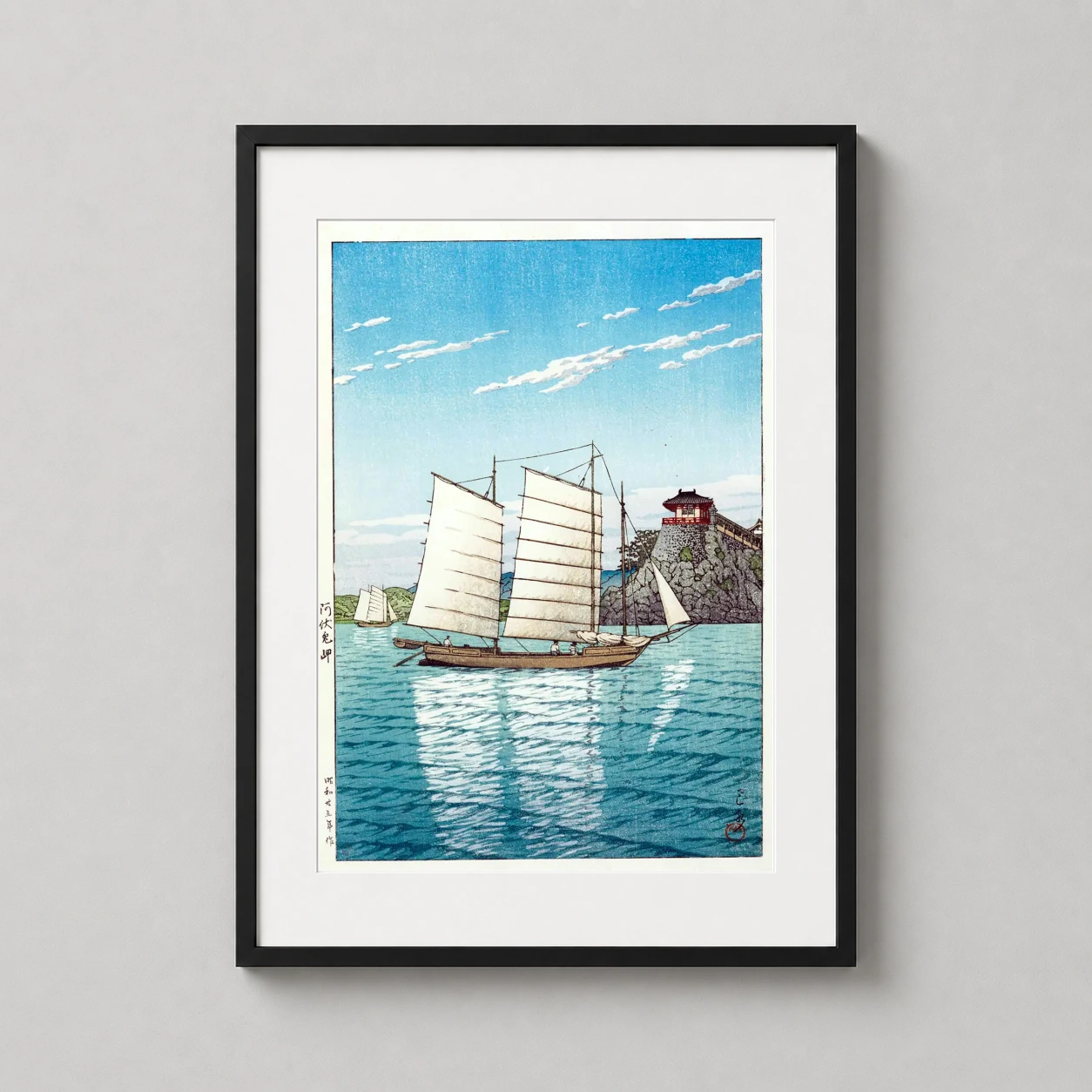 Room mockup of Tsuchiya Koitsu Japanese Sailboat Coastal Scene Art Print, displayed as framed wall art in a bedroom setting as a portrait print with blue tones.