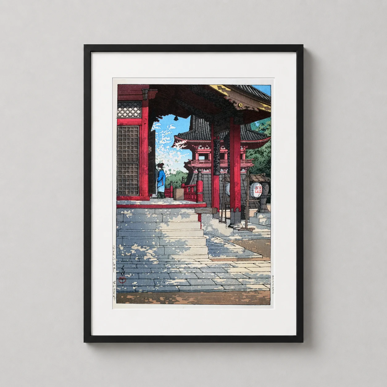 Room mockup of Fudo Hall in Meguro Kawase Hasui Woodblock Art Print, displayed as framed wall art in a bedroom setting as a portrait print with blue and red tones.