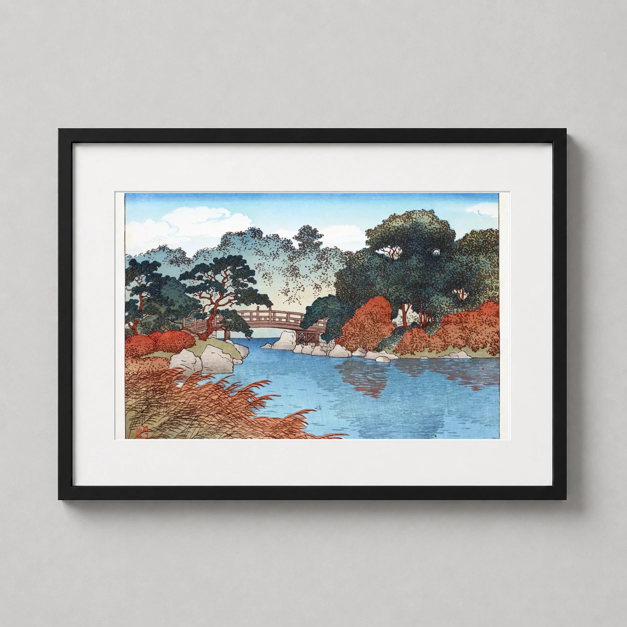 Room mockup of Garden in Autumn by Kawase Hasui, 1920 Japanese Woodblock Art Print, displayed as framed wall art in a bedroom setting as a landscape print with blue tones.