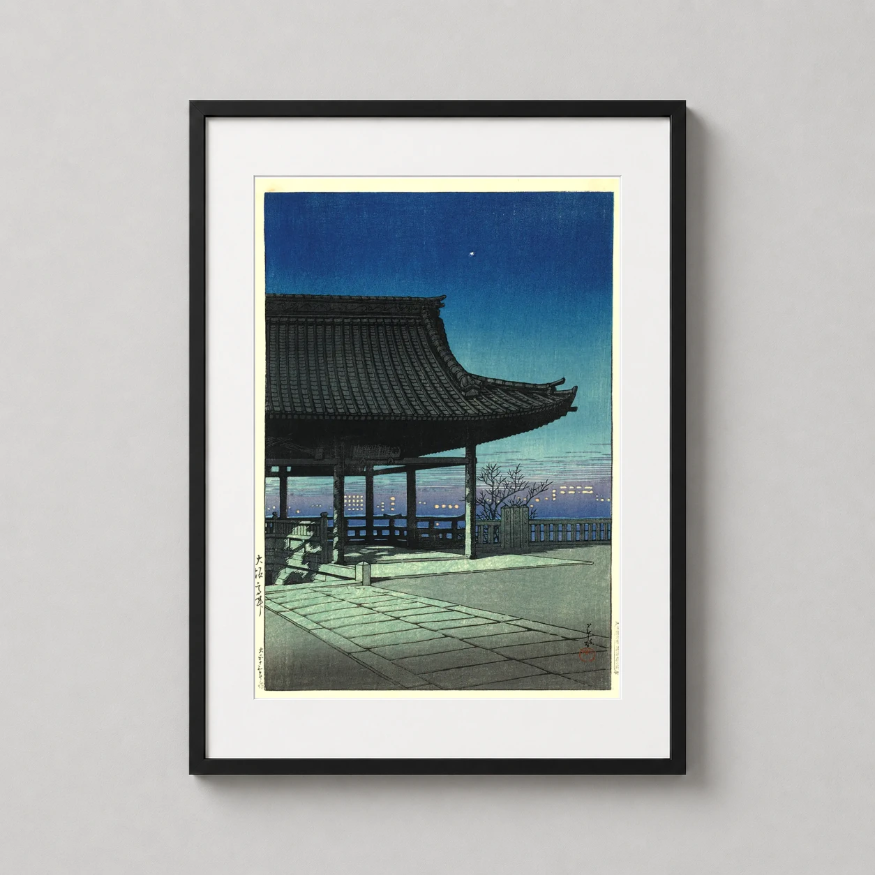 Room mockup of Kawase Hasui Kozu District Osaka Evening Woodblock Art Print, displayed as framed wall art in a bedroom setting as a portrait print with blue tones.