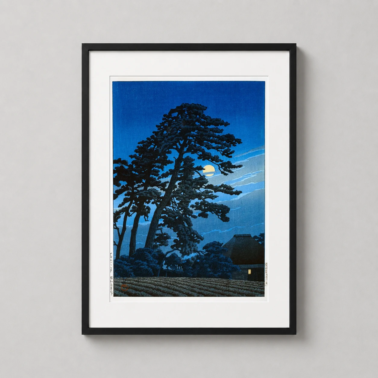Room mockup of Moon at Umagome by Hasui Kawase Nocturnal Landscape Art Print, displayed as framed wall art in a bedroom setting as a portrait print with blue tones.