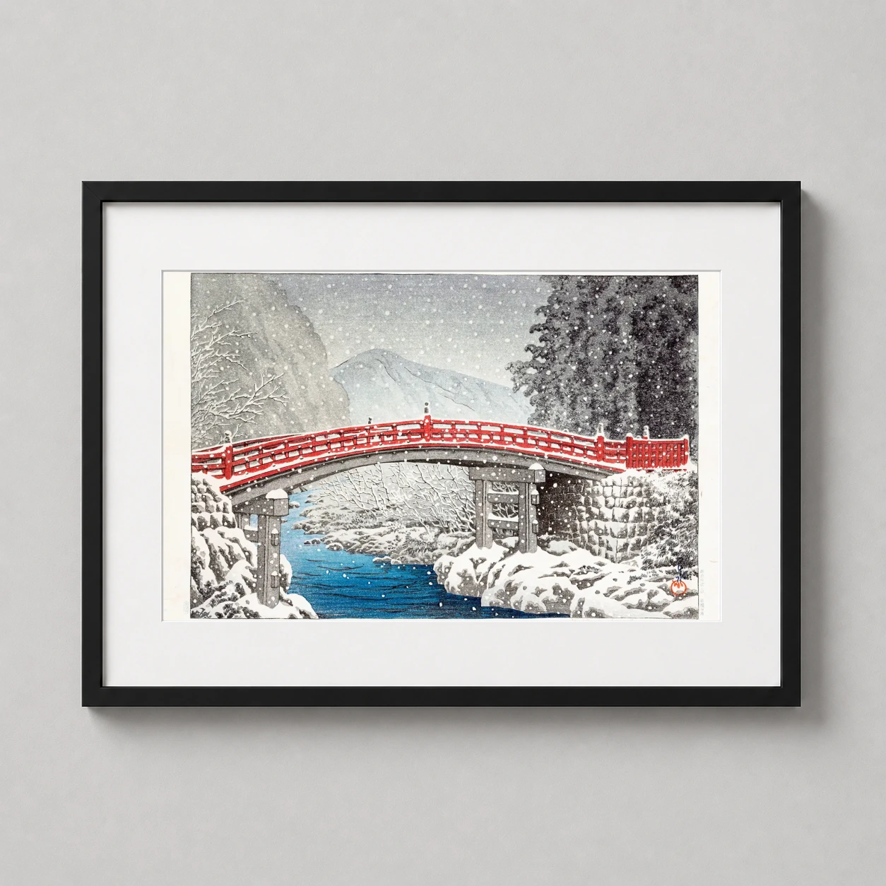 Room mockup of Classic Nikko Snow Bridge Art Print, Japanese Woodblock Decor, displayed as framed wall art in a bedroom setting as a landscape print with blue and red tones.