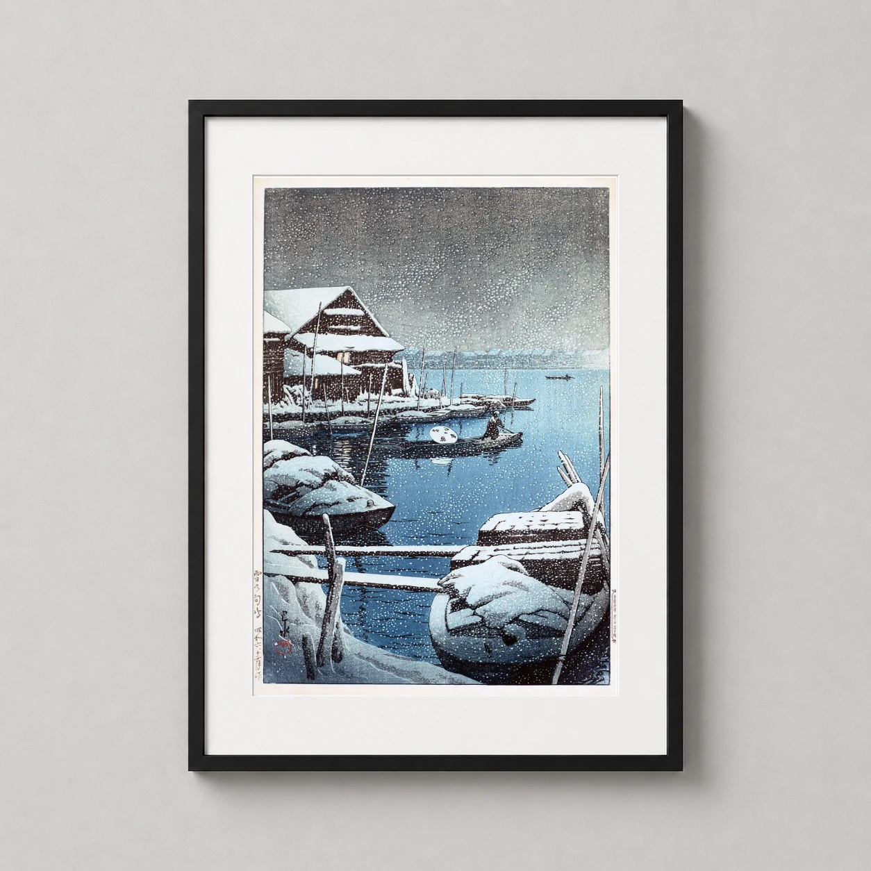 Room mockup of Snow at Mukojima by Kawase Hasui Japanese Woodblock Art Print, displayed as framed wall art in a bedroom setting as a portrait print.