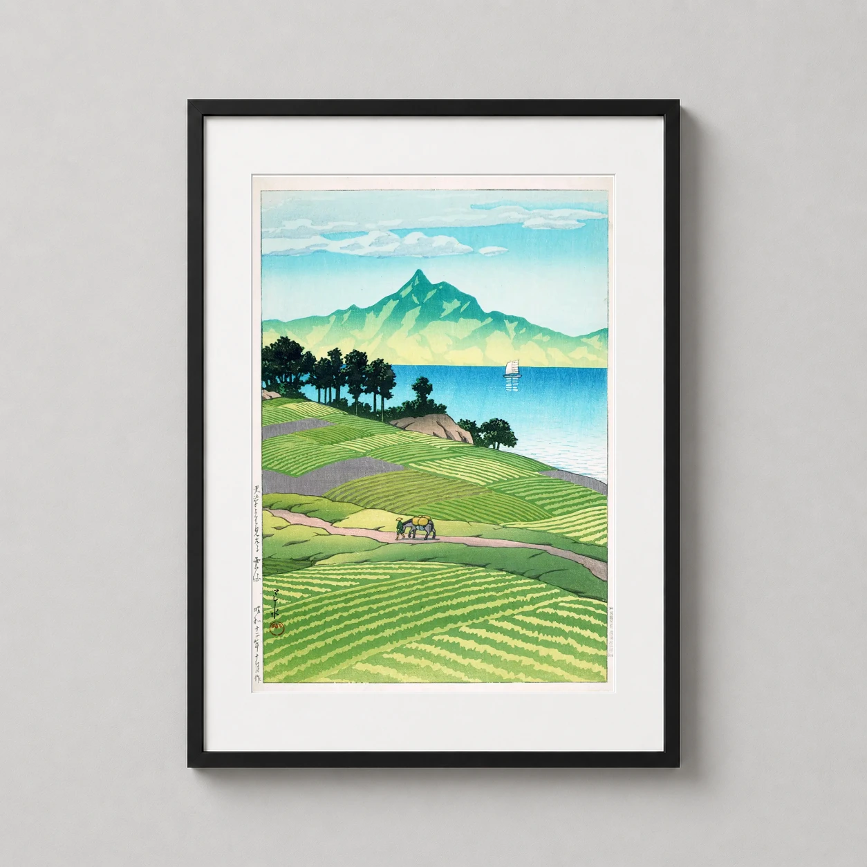 Room mockup of Mount Unzen from Amakusa by Kawase Hasui Japanese Art Print, displayed as framed wall art in a bedroom setting as a portrait print with blue and green tones.
