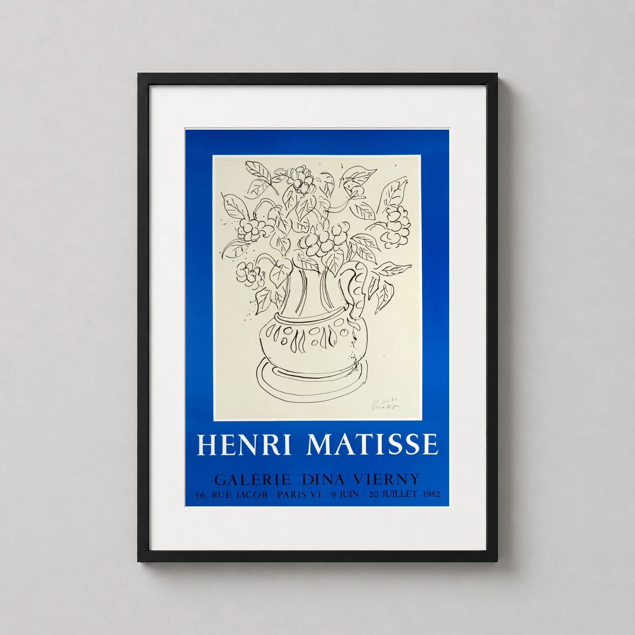 Room mockup of Henri Matisse Galerie Dina Vierny Floral Exhibition Art Print, displayed as framed wall art in a bedroom setting as a portrait print with blue and black tones.