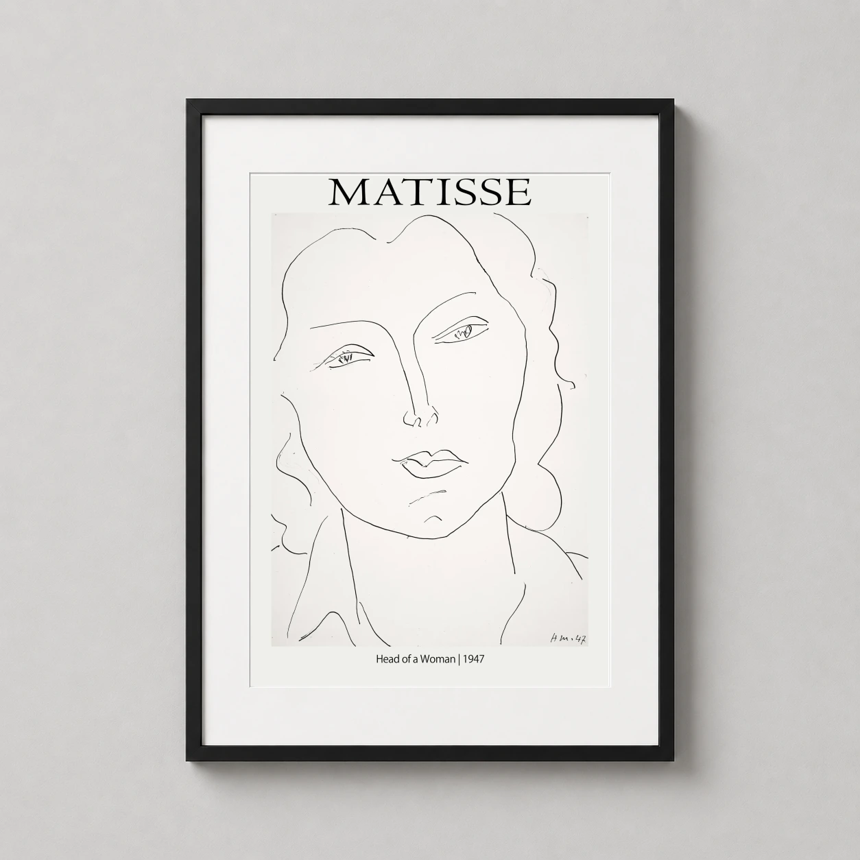 Room mockup of Matisse Head of a Woman 1947 Exhibition Art Print, displayed as framed wall art in a living room setting as a portrait print with black and white tones.