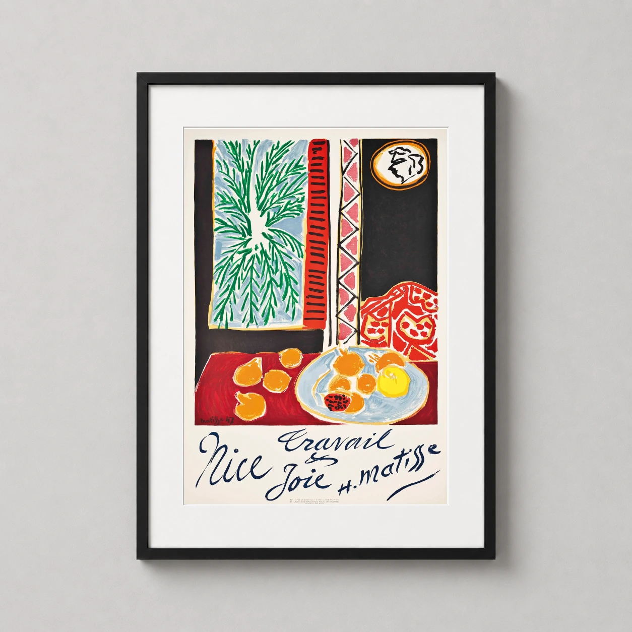 Room mockup of Matisse Nice Travail et Joie 1947 Exhibition Art Print, displayed as framed wall art in a living room setting as a portrait print with green and red tones.
