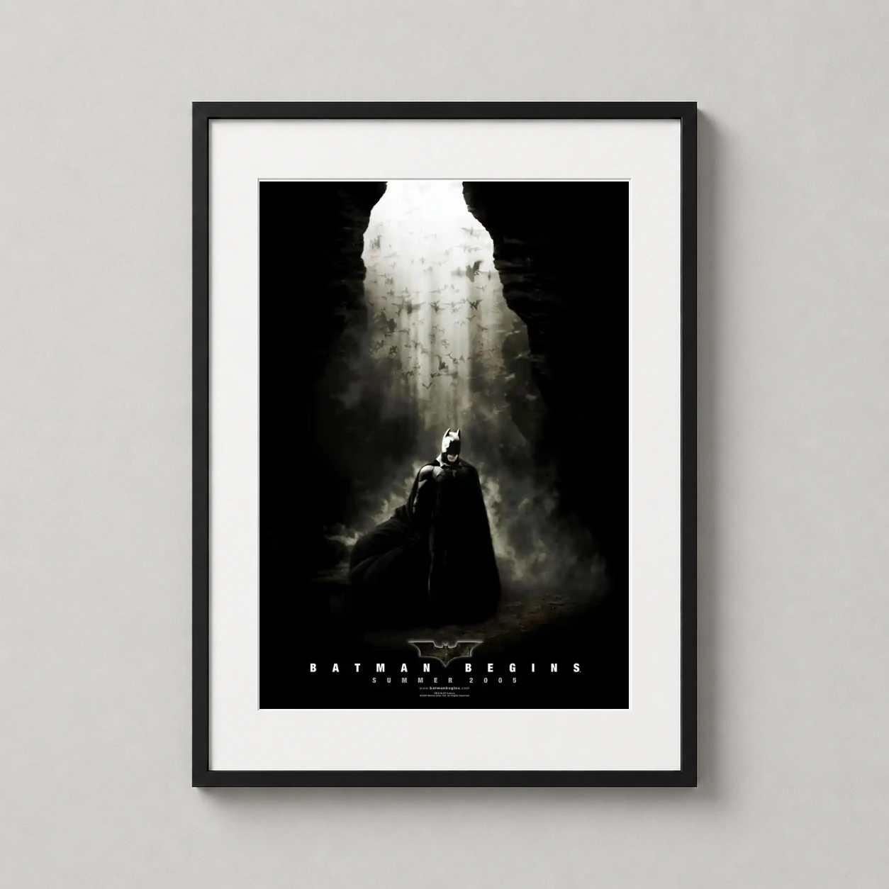 Batman Begins Cave Scene — high-contrast cinematic poster featuring Batman standing amidst