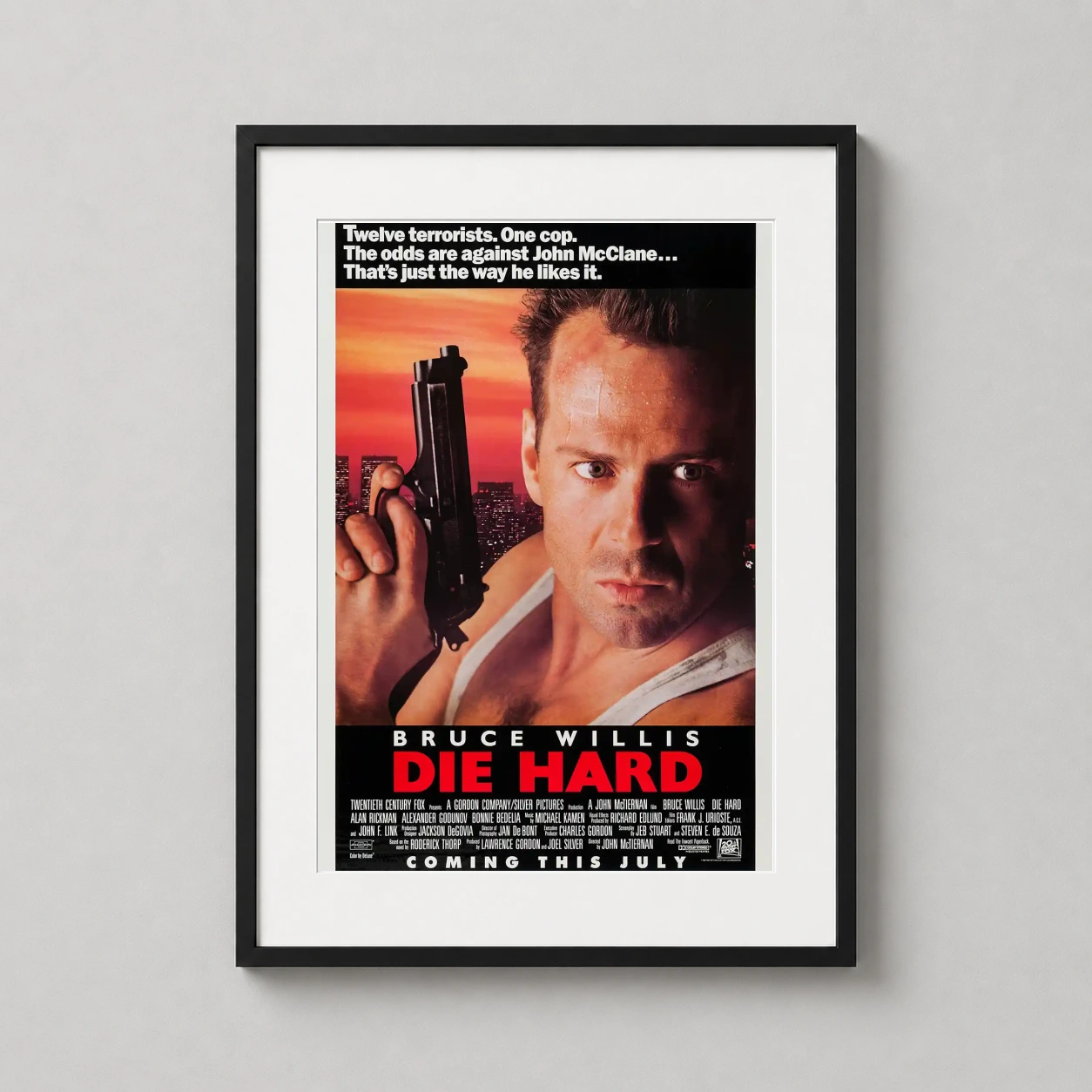 Room mockup of Die Hard 1988 John McClane Action Movie Poster, displayed as framed wall art in a home theater setting as a portrait print with gold tones.