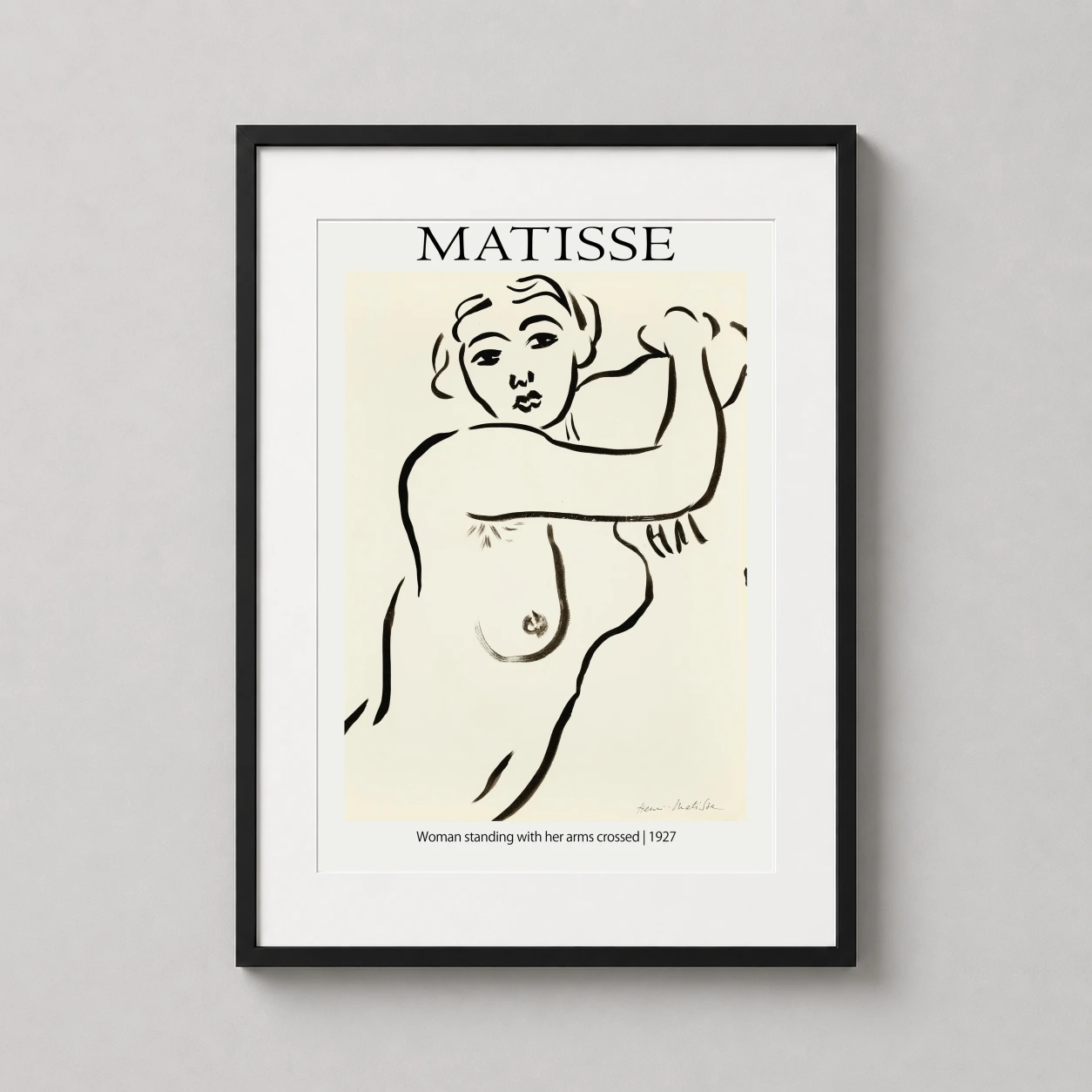 Room mockup of Henri Matisse Woman Standing with her Arms Crossed 1927 Art Print, displayed as framed wall art in a living room setting as a portrait print with black and white tones.