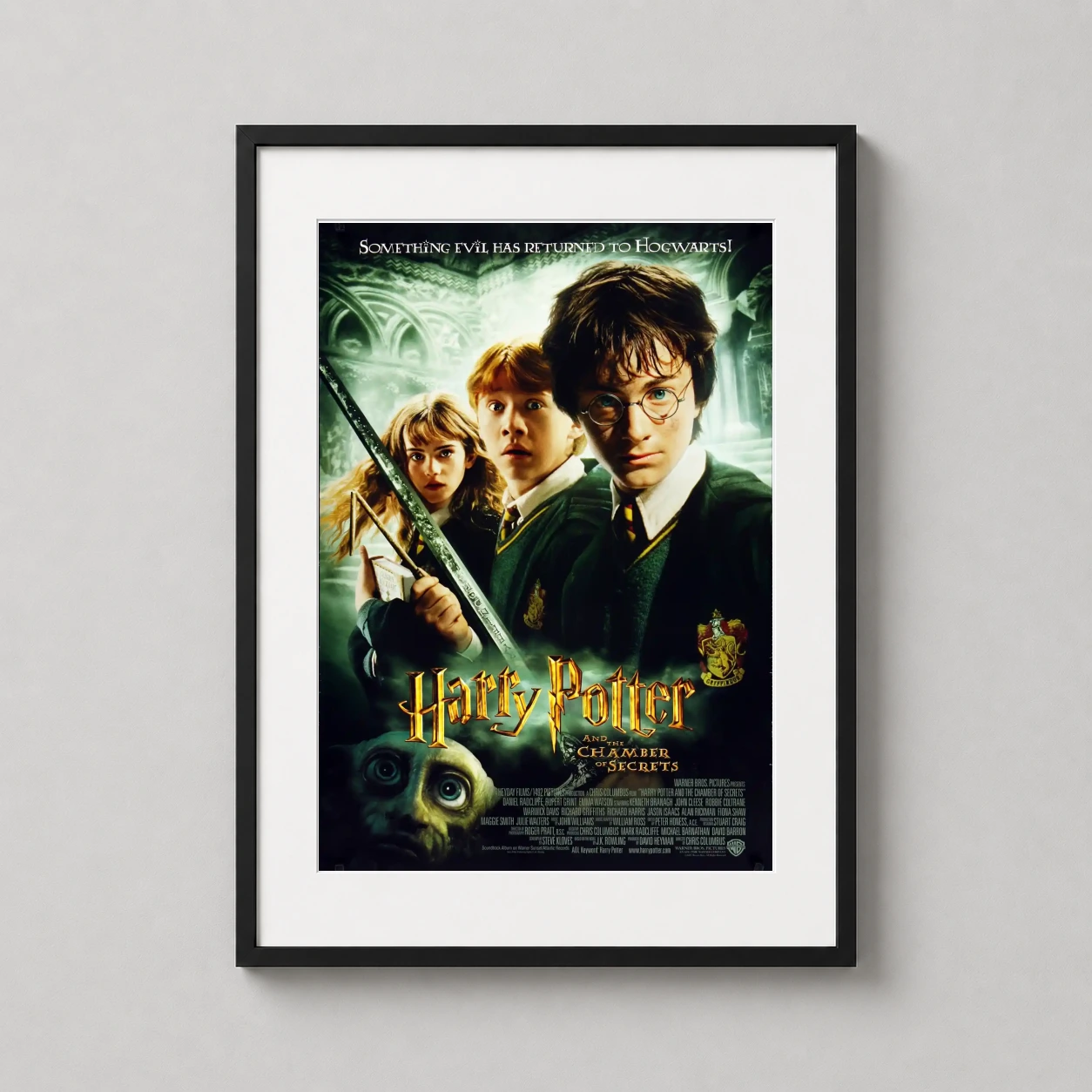 Room mockup of Harry Potter and the Chamber of Secrets Movie Poster, displayed as framed wall art in a home theater setting as a portrait print with green and gold tones.