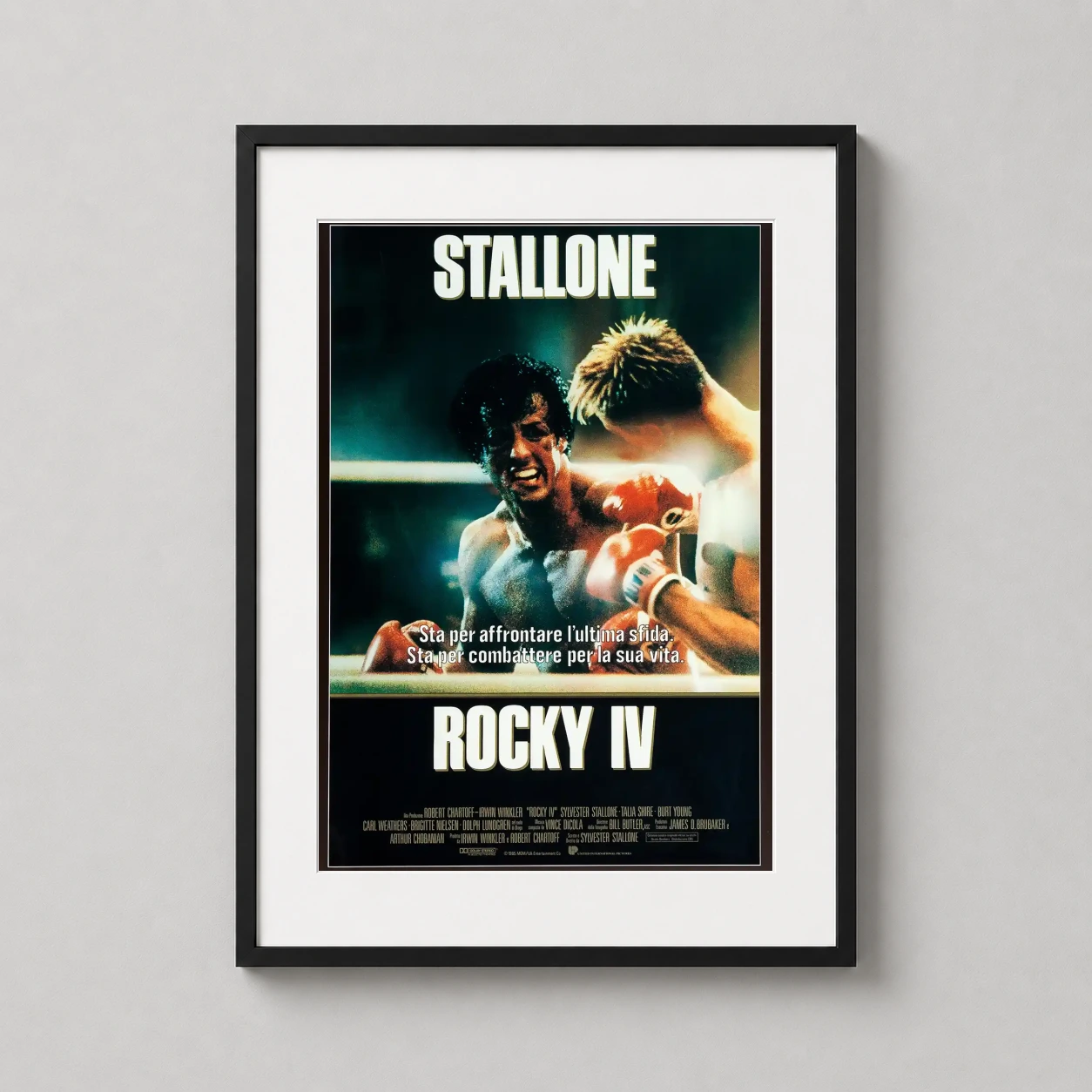Room mockup of Rocky IV 1985 Movie Stallone vs Drago Boxing Match Movie Poster, displayed as framed wall art in a home theater setting as a portrait print.
