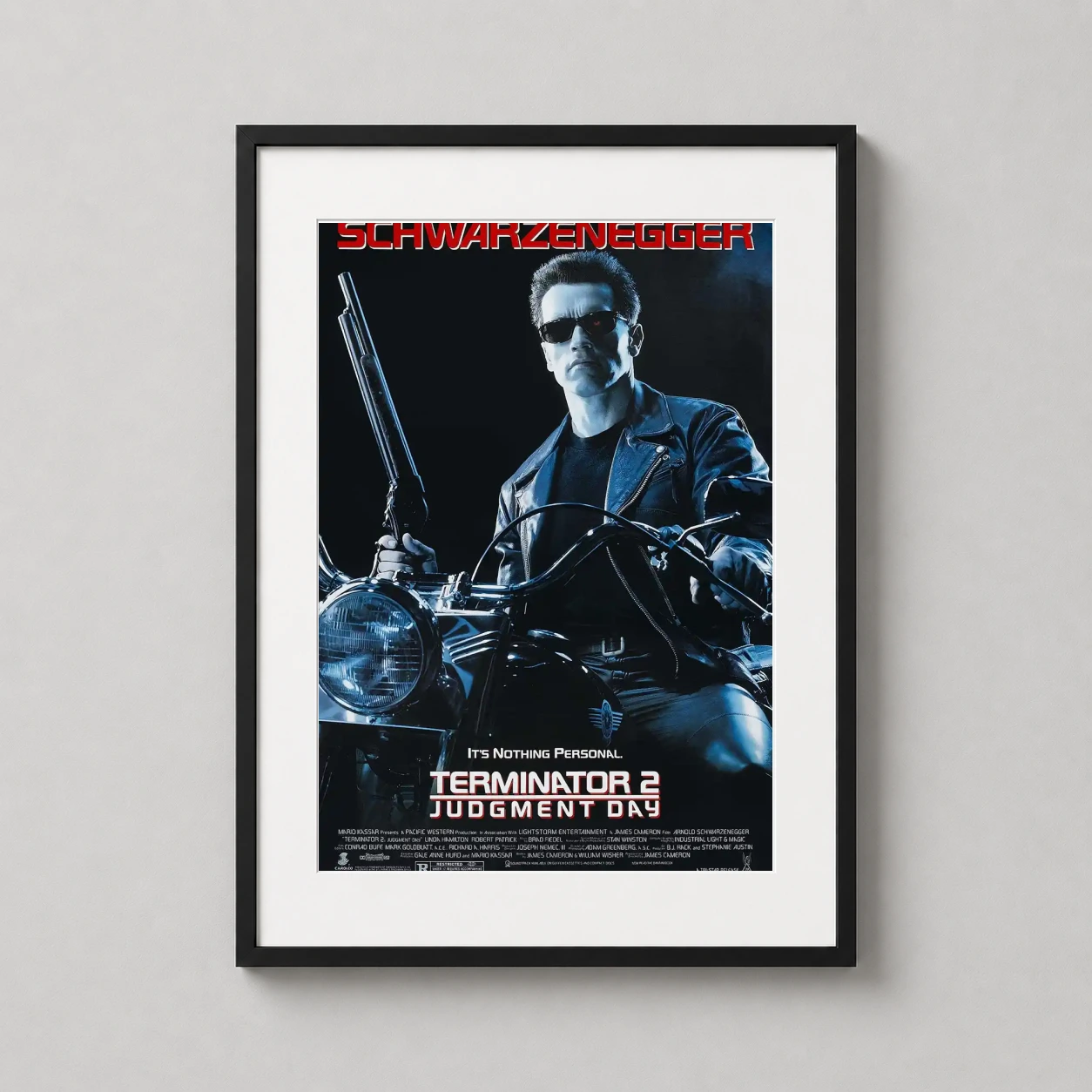 Room mockup of Terminator 2 Judgment Day T-800 on Motorcycle Movie Poster, displayed as framed wall art in a home theater setting as a portrait print with red tones.