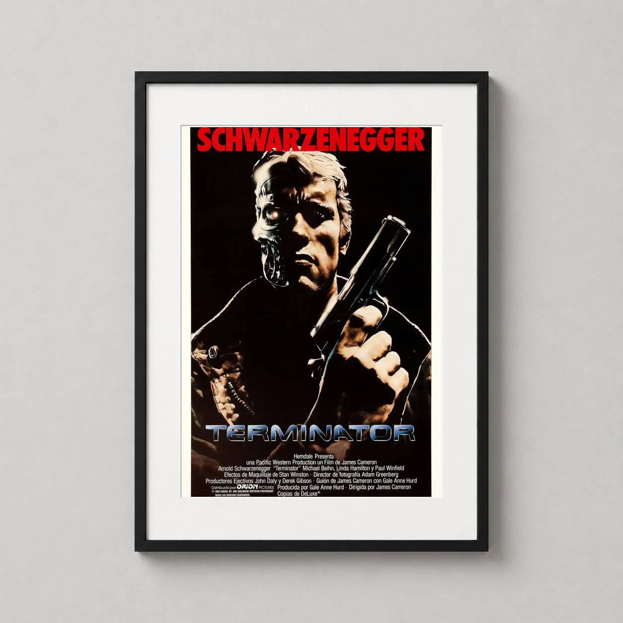 Room mockup of Terminator 1984 Movie Arnold Schwarzenegger, Action Movie Poster, displayed as framed wall art in a home theater setting as a portrait print with red tones.
