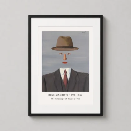 A framed The Landscape of Baucis art print by Rene Magritte hanging on a minimalist white wall in a modern office.