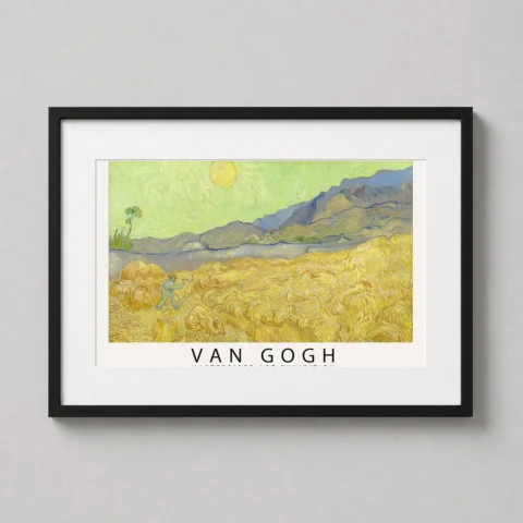 A framed Wheatfield with a Reaper art print by Van Gogh hanging in a modern living room above a minimalist wooden side table.