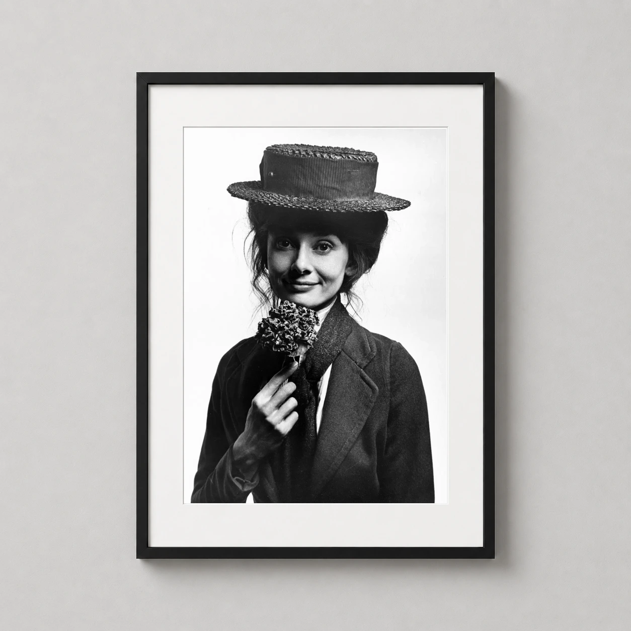 Room mockup of Audrey Hepburn as Eliza Doolittle 1963 Photography Print, displayed as framed wall art in a office setting as a portrait print with black and white tones.
