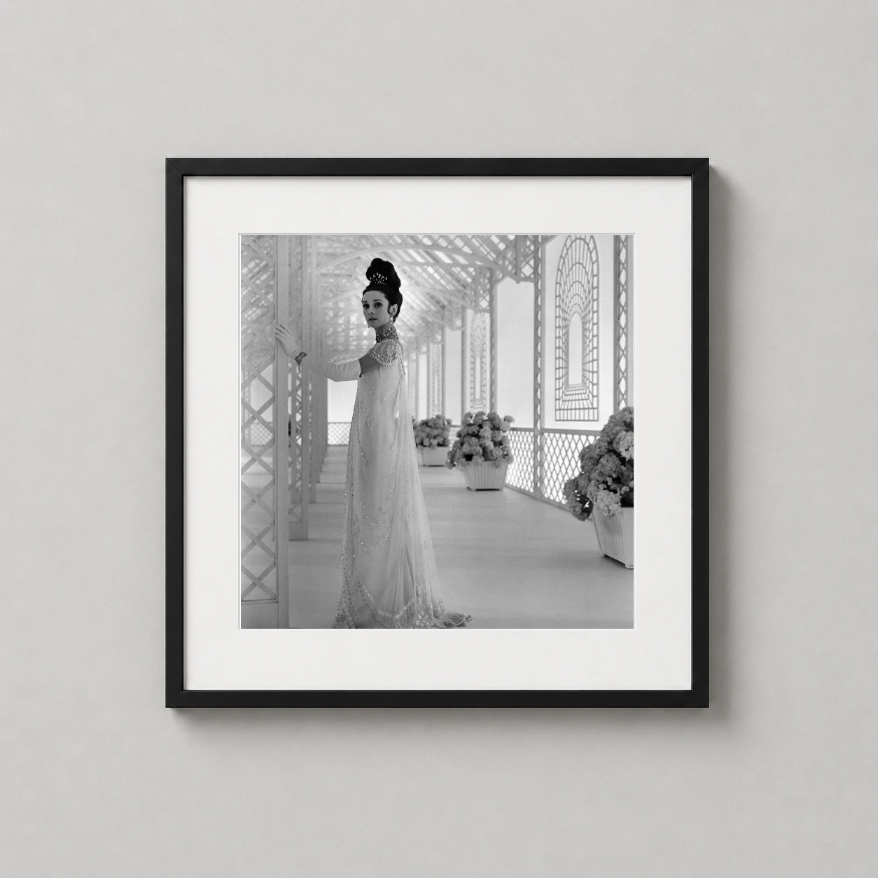 Room mockup of Audrey Hepburn Eliza Doolittle My Fair Lady Portrait Photography Print, displayed as framed wall art in a home theater setting as a square print with black and white tones.