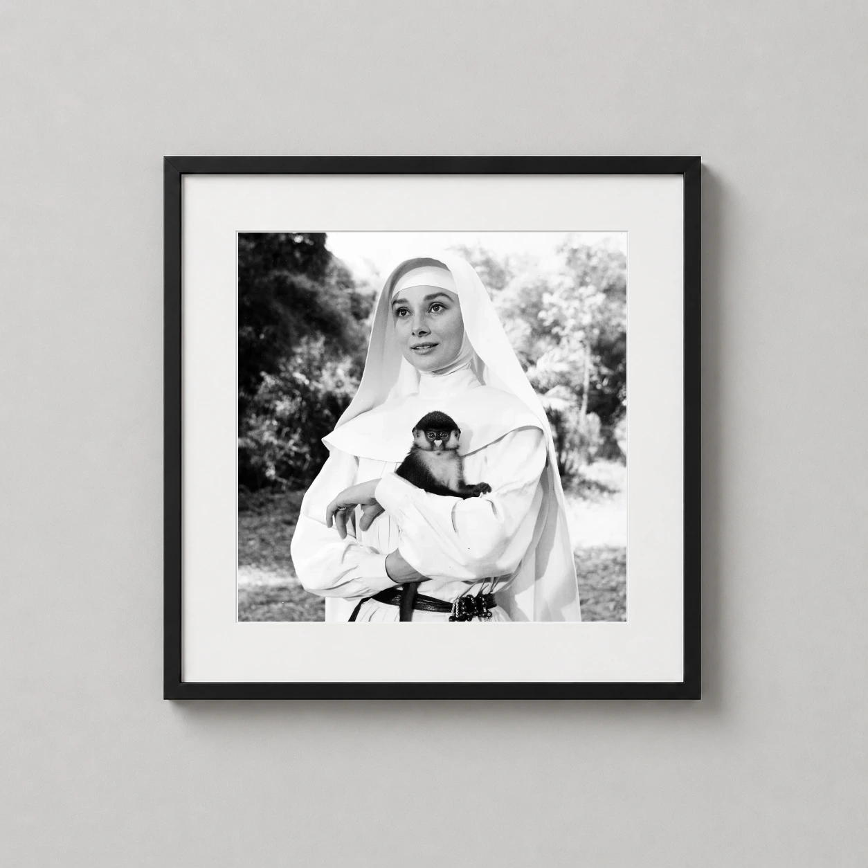 Audrey Hepburn Nun's Story — monochrome portrait of Audrey Hepburn as Sister Luke holding a small