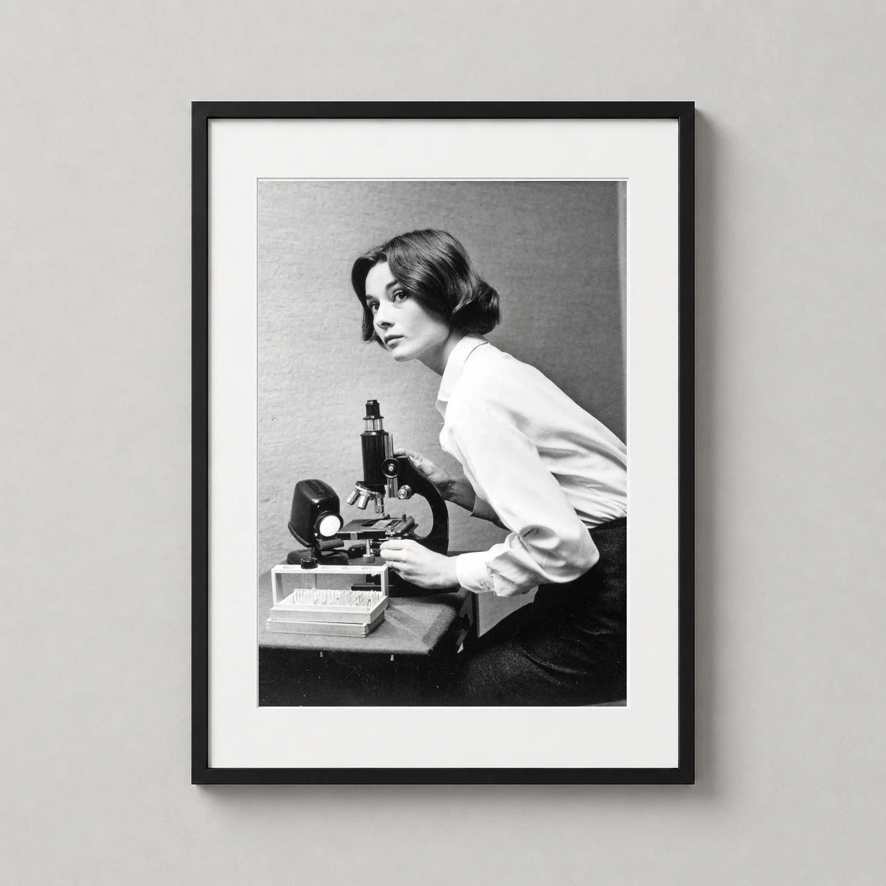 Audrey Hepburn As Sister — audrey Hepburn leans over a vintage laboratory microscope in this