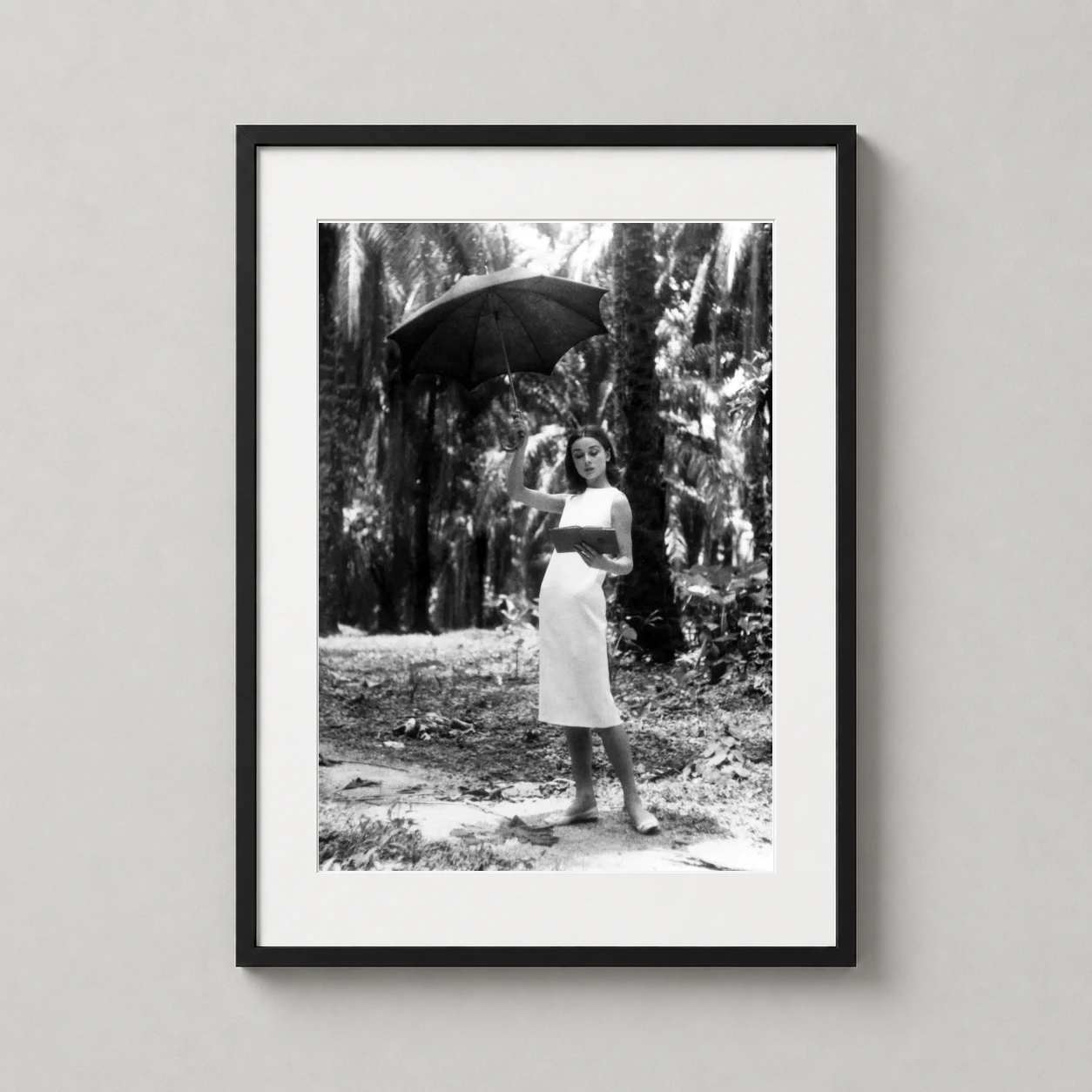 Room mockup of Audrey Hepburn on the Set of The Nun's Story Black and White Photography Print, displayed as framed wall art in a home theater setting as a portrait print with black and white tones.