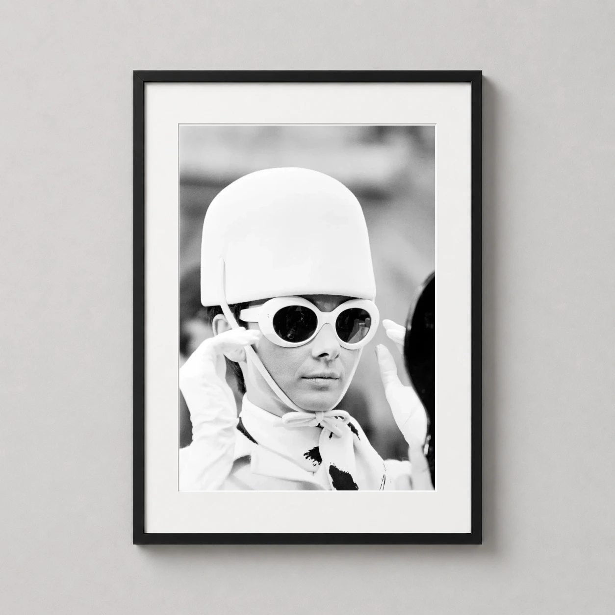 Room mockup of Audrey Hepburn 1966 Mod Fashion White Sunglasses Photography Print, displayed as framed wall art in a home theater setting as a portrait print with black and white tones.