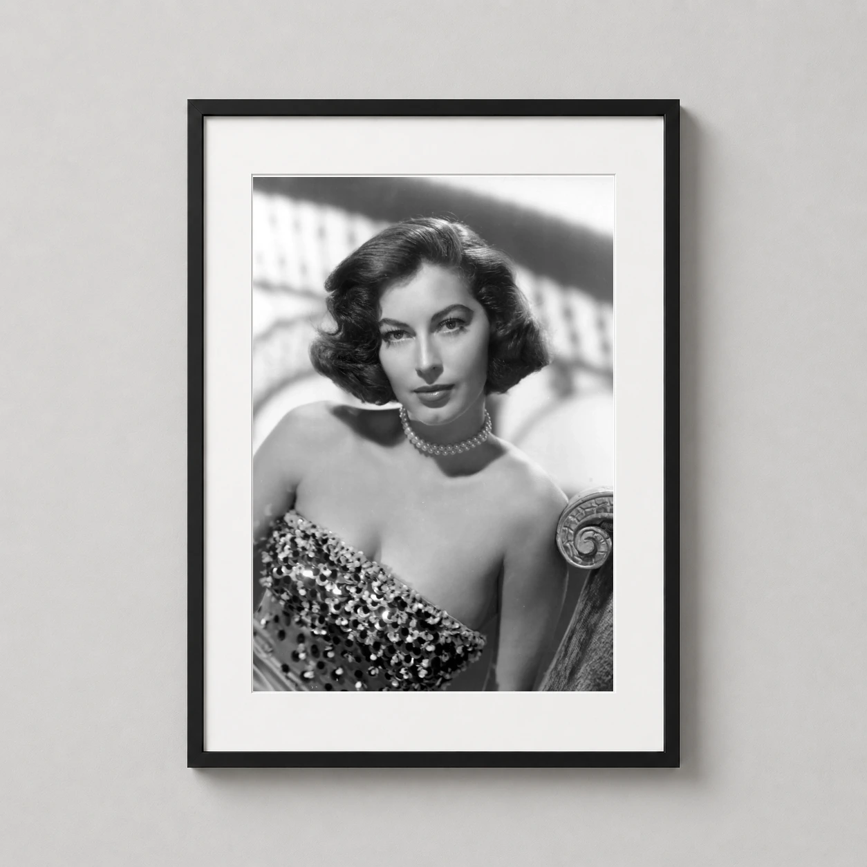 Room mockup of Ava Gardner in Sequined Evening Gown Hollywood Photography Print, displayed as framed wall art in a office setting as a portrait print with black and white and gold tones.