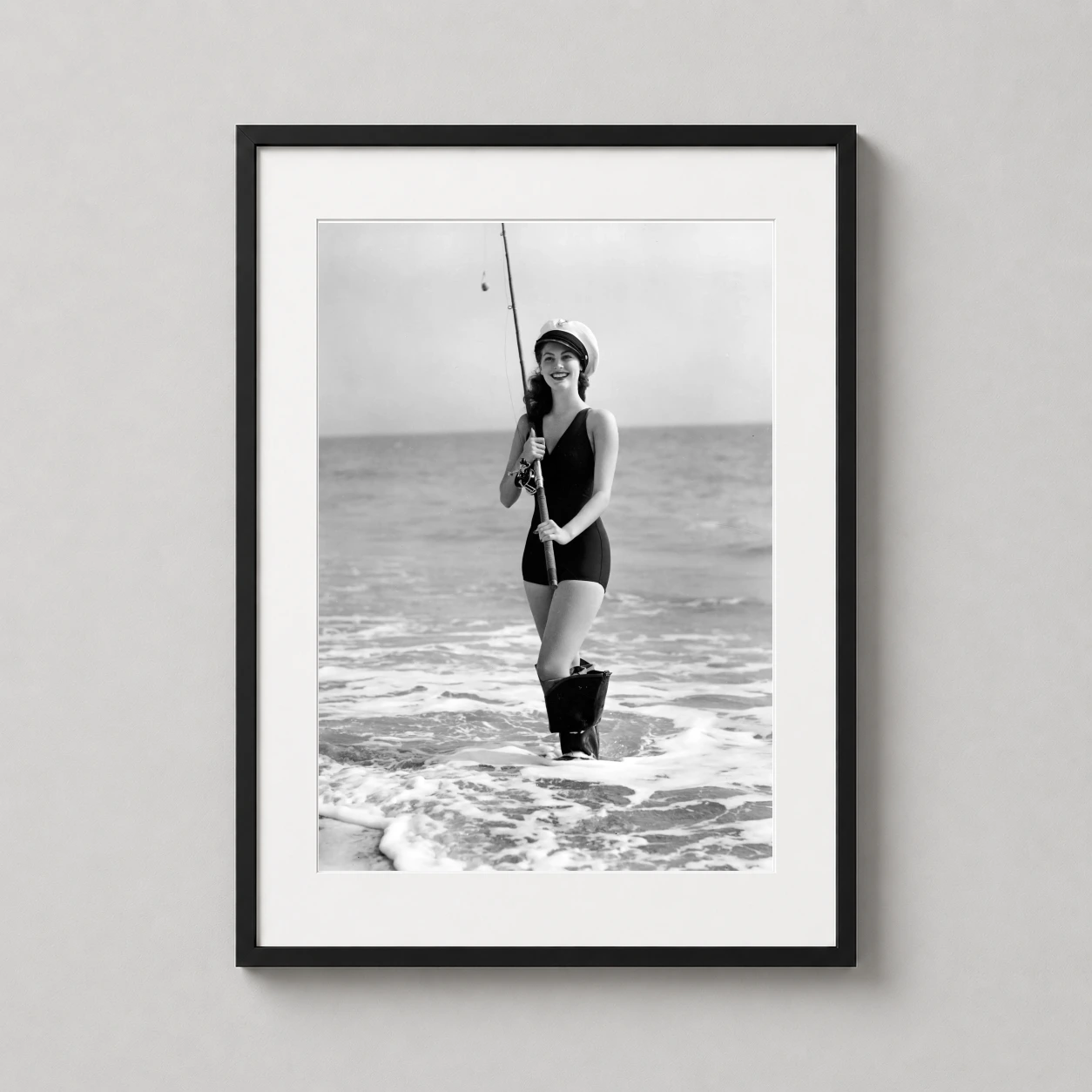 Ava Gardner Fishing Beach — ava Gardner stands in the surf wearing a dark swimsuit and captain's