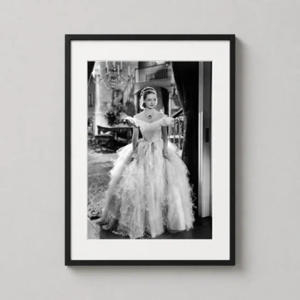 A framed Jezebel movie art print featuring Bette Davis in a white gown displayed on a neutral wall in a stylish living room.