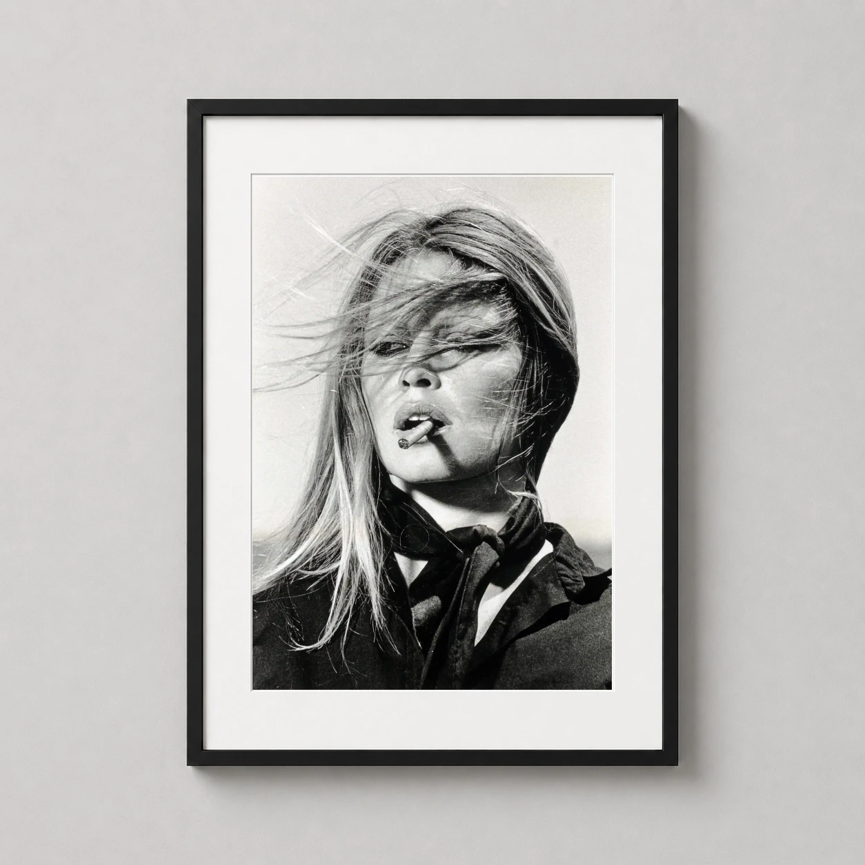 Room mockup of Brigitte Bardot Spain 1971 Windblown Portrait Photography Print, displayed as framed wall art in a office setting as a portrait print with black and white tones.