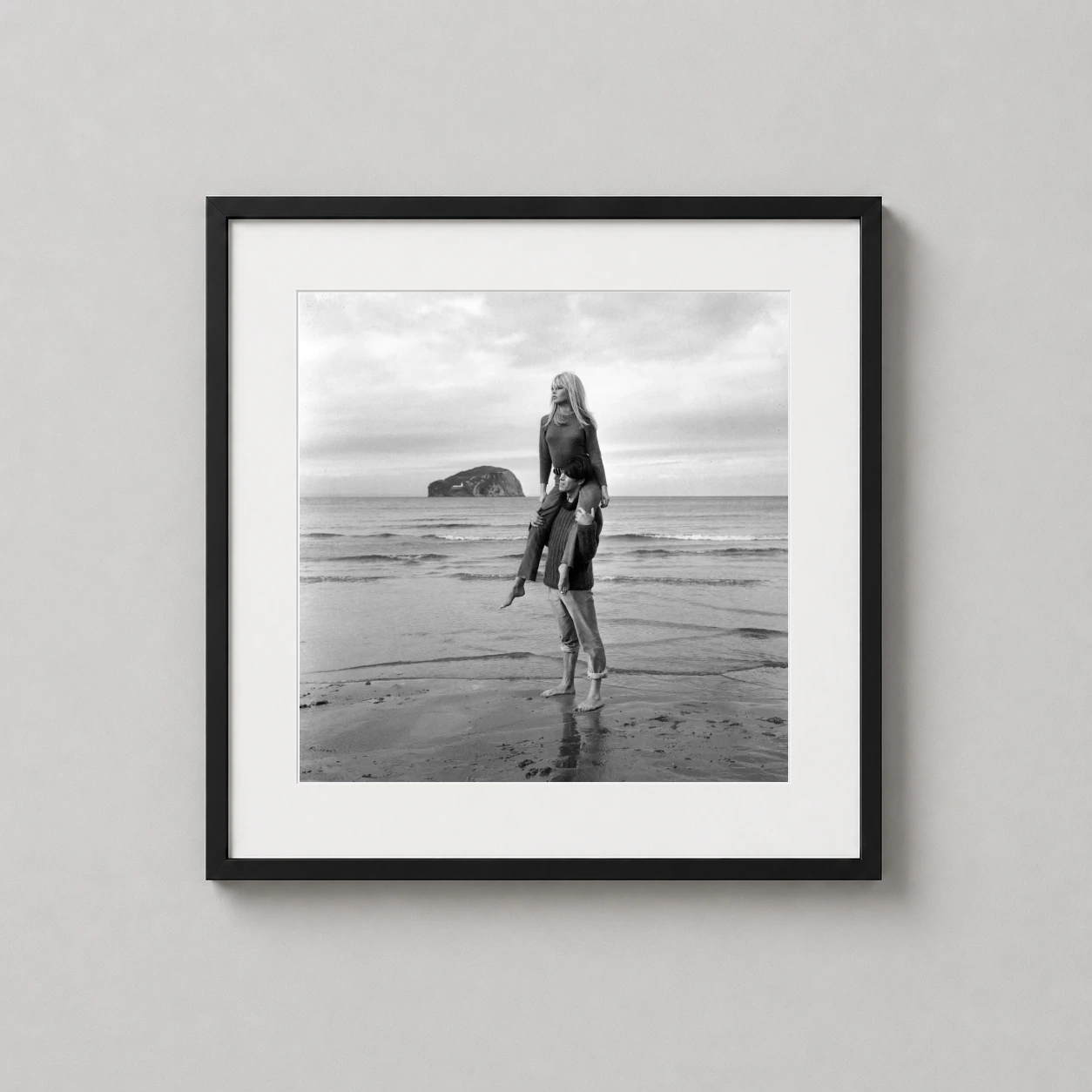 Brigitte Bardot Piggyback Beach — nostalgic black and white photograph of Brigitte Bardot enjoying a