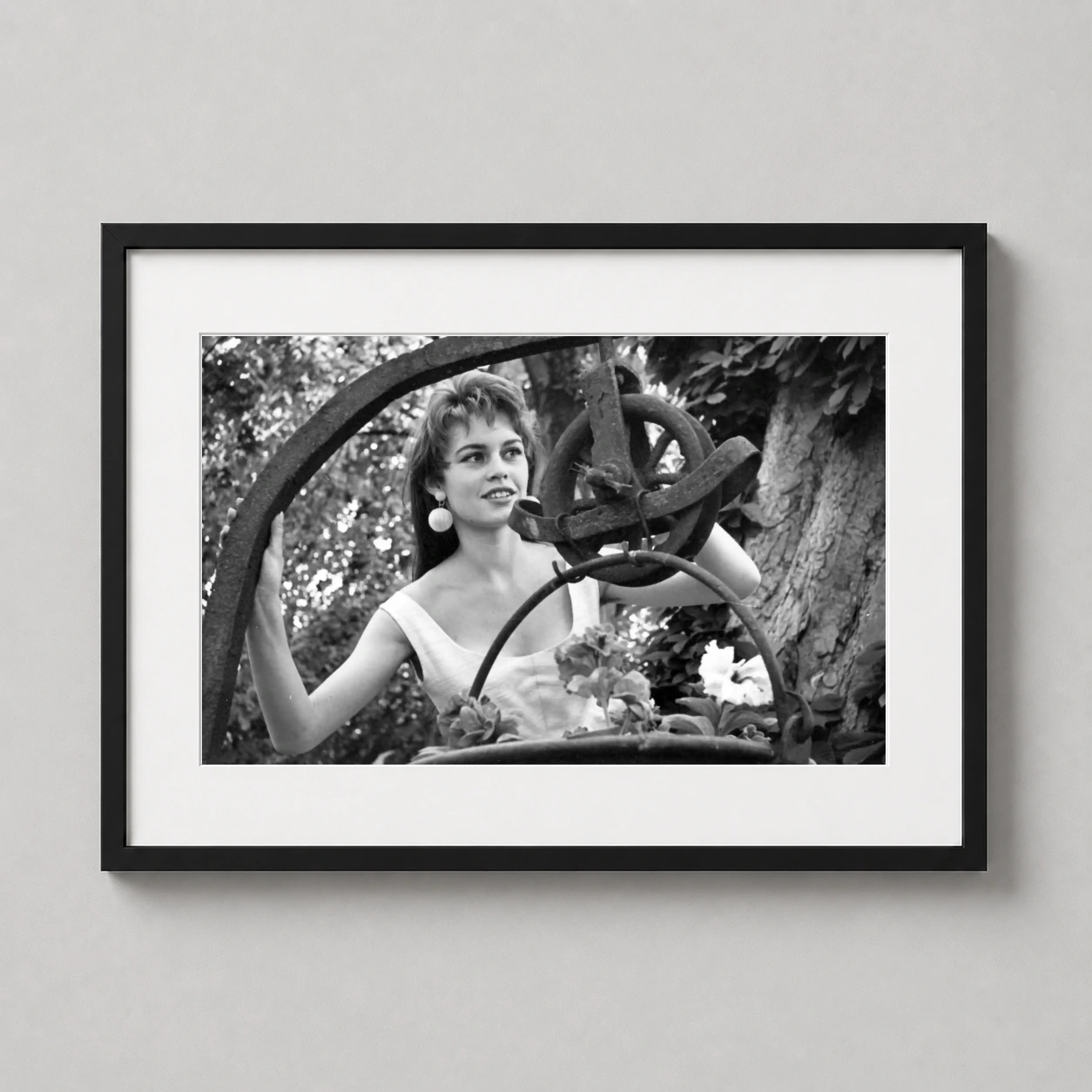 Brigitte Bardot Smiling Garden — candid black and white 1954 portrait of Brigitte Bardot smiling in a