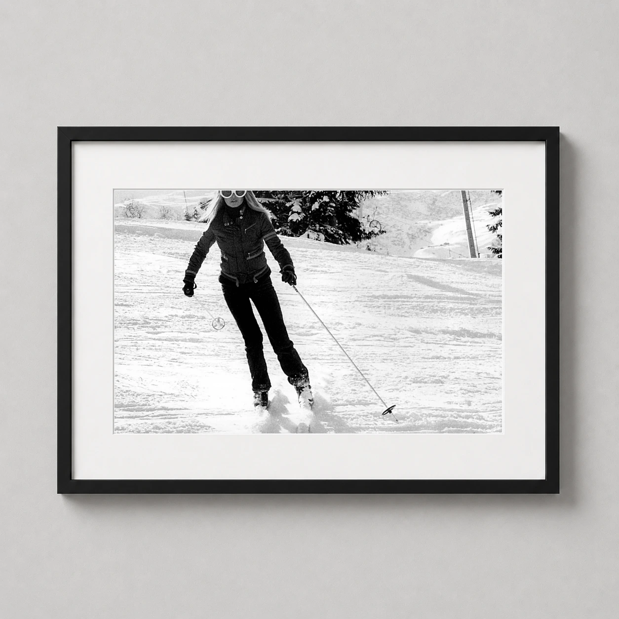 Room mockup of Brigitte Bardot 1970s Skiing Black and White Photography Print, displayed as framed wall art in a office setting as a landscape print with black and white tones.
