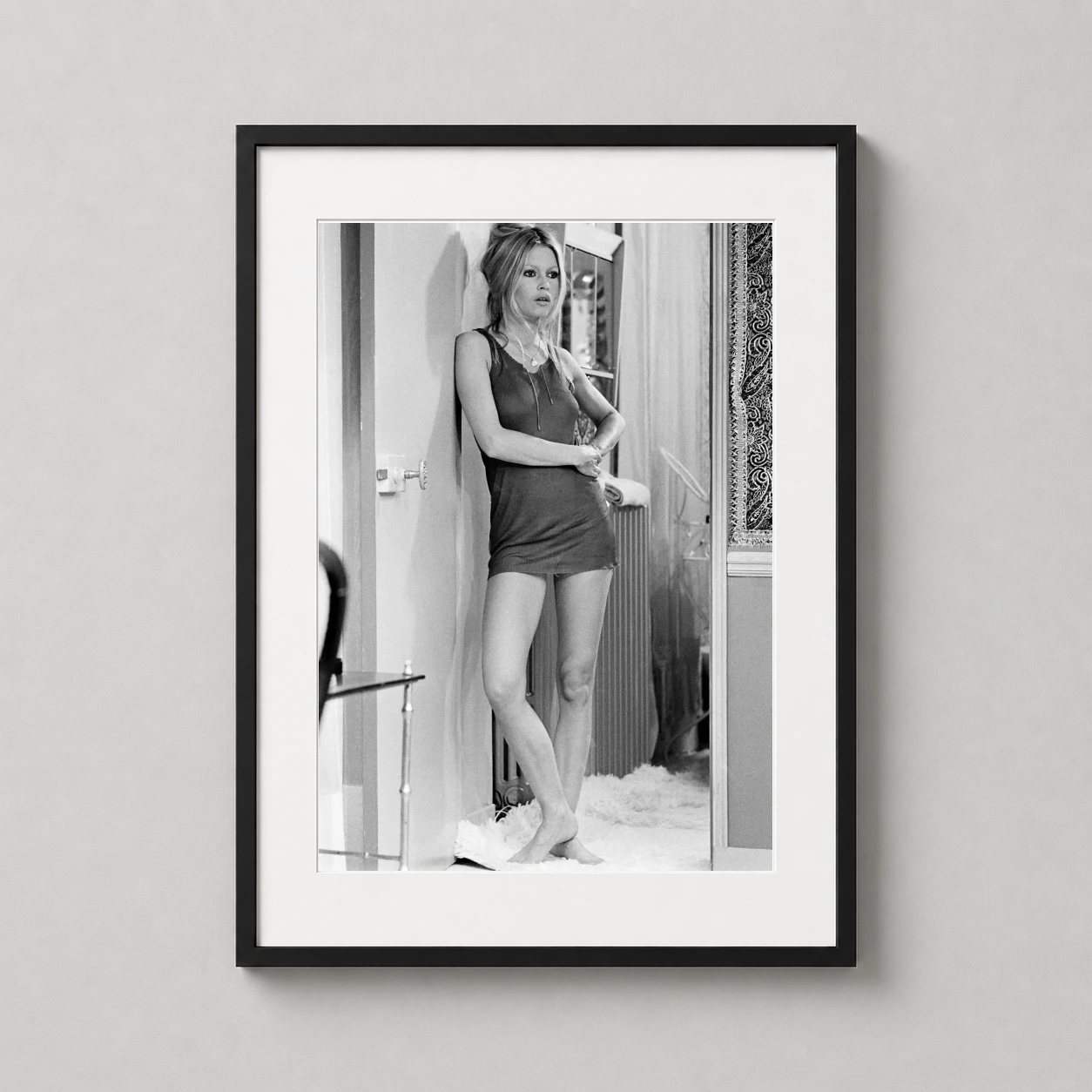 Room mockup of Brigitte Bardot in Les Novices 1970 Film Photography Print, displayed as framed wall art in a office setting as a portrait print with black and white tones.