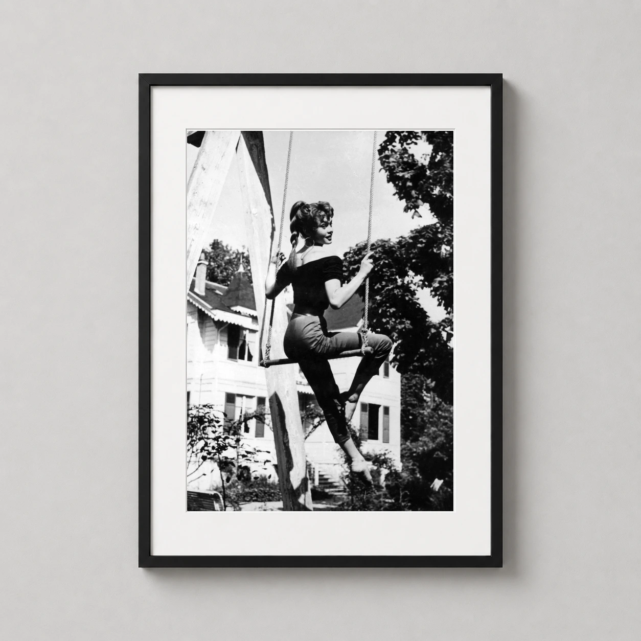 Brigitte Bardot Swing Black — playful black and white photograph of Brigitte Bardot sitting on a rope