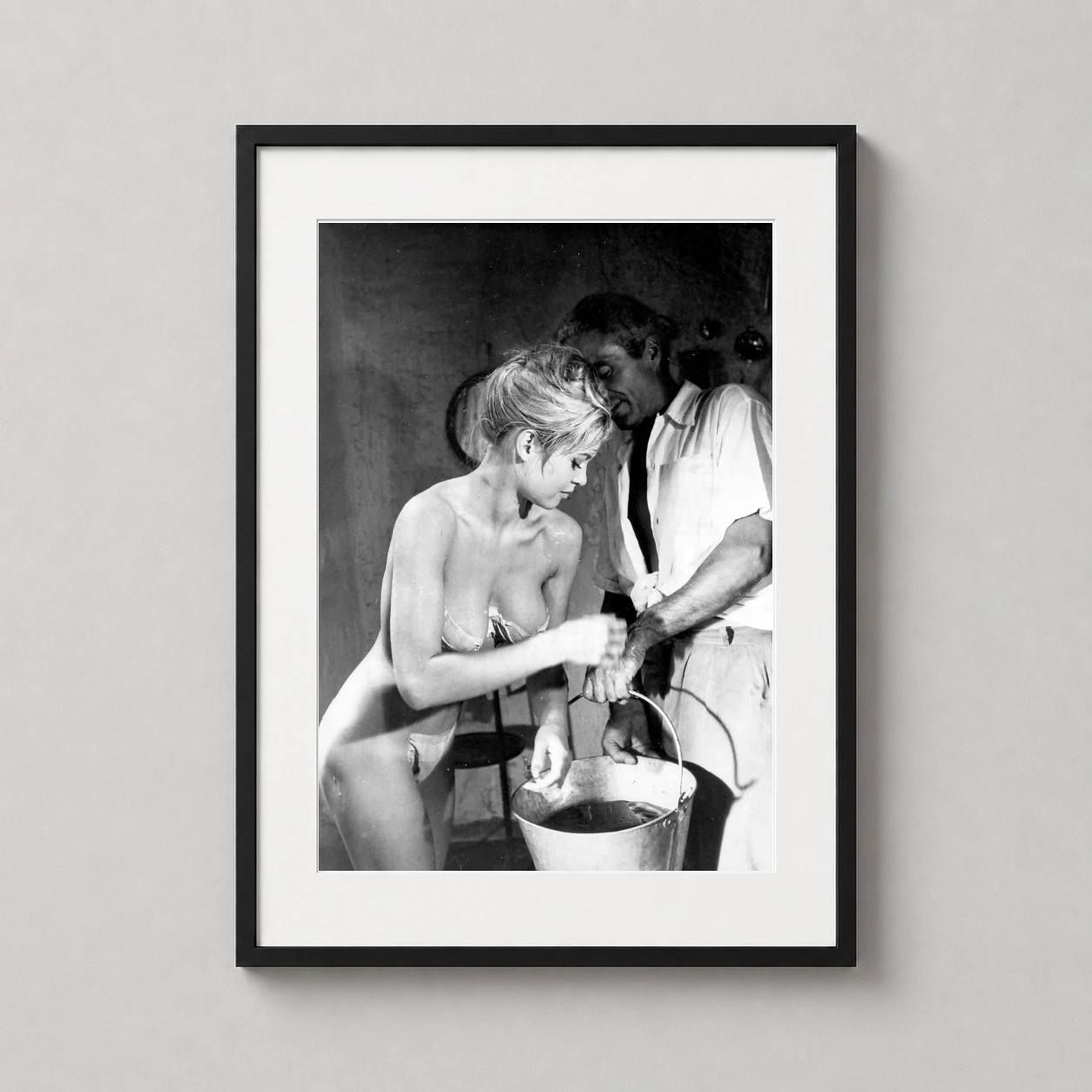 Room mockup of Brigitte Bardot Candid Bath Scene Black and White Photography Print, displayed as framed wall art in a office setting as a portrait print with black and white tones.