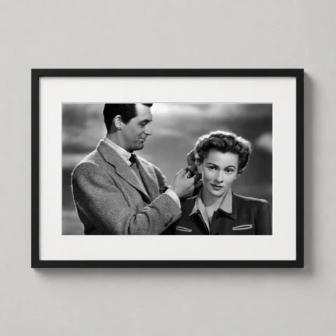 A framed Suspicion movie art print featuring Cary Grant and Joan Fontaine displayed on a textured living room wall.