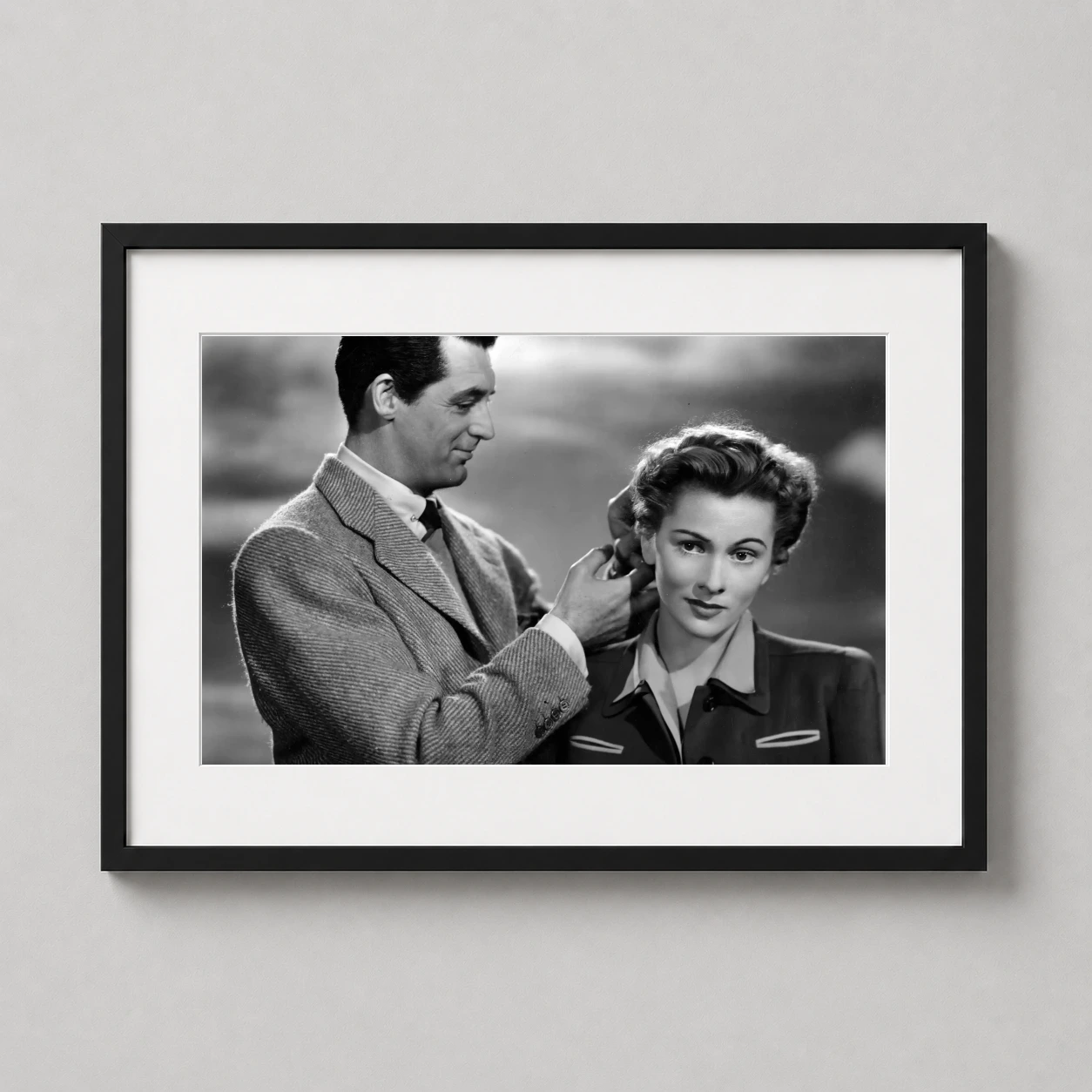 Suspicion — black and white vintage photograph featuring Cary Grant adjusting Joan