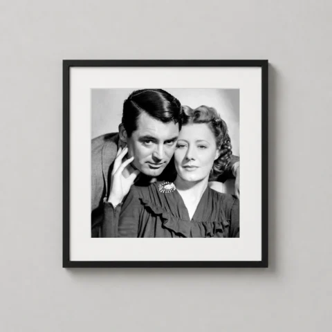 A framed print of the My Favorite Wife 1940 portrait featuring Cary Grant and Irene Dunne hanging in a sophisticated home office.
