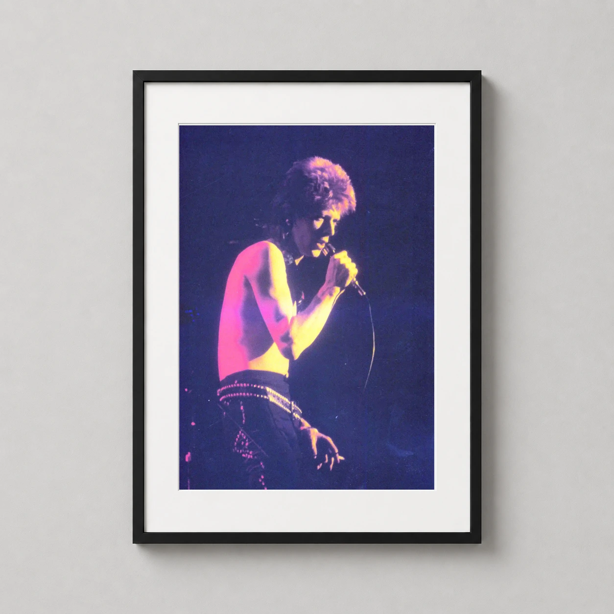 David Bowie Moonage Daydream — grainy, high-contrast concert photograph of David Bowie performing as