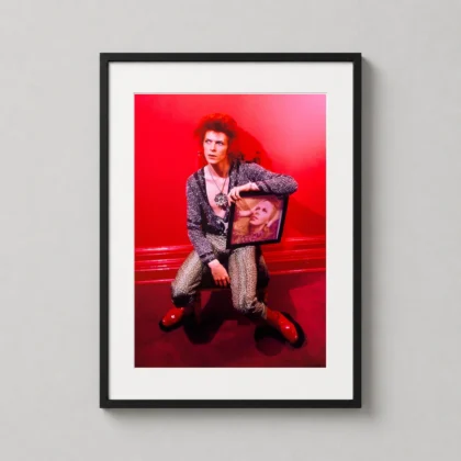 David Bowie red room portrait print showing a saturated red-room portrait with Bowie holding a framed image as David Bowie